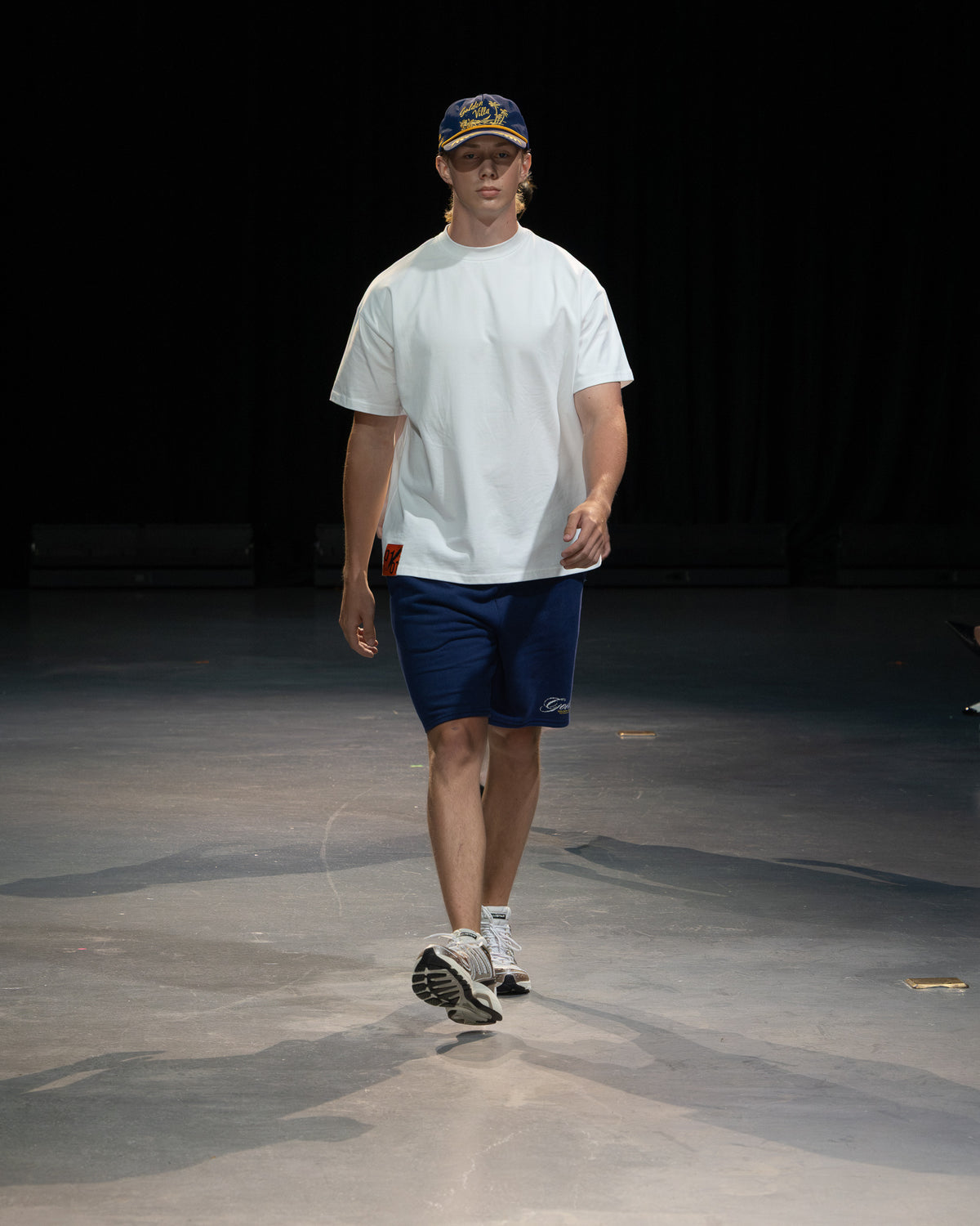 Golden Angels runway: White T-shirt, navy shorts and a cap